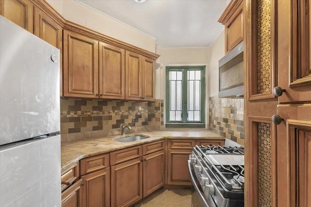 kitchen with stainless steel appliances, a sink, brown cabinets, light stone countertops, and tasteful backsplash