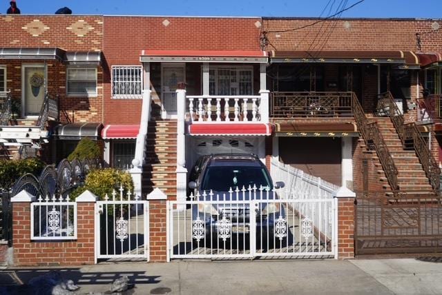 view of building exterior featuring fence and stairs