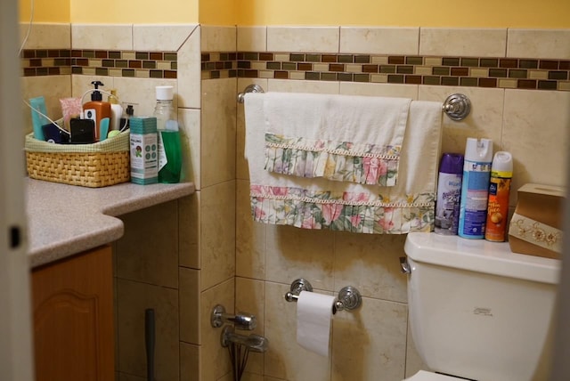 bathroom with tile walls and toilet