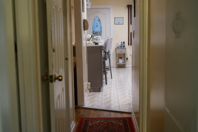 corridor featuring tile patterned floors and baseboards