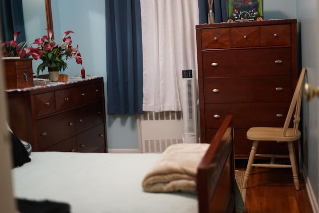 bedroom with wood finished floors and radiator heating unit