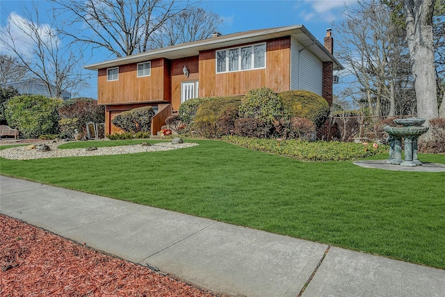 bi-level home featuring a chimney, fence, and a front lawn