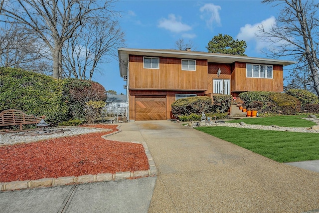 raised ranch with a garage and concrete driveway