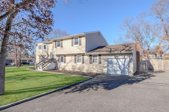 raised ranch featuring a garage and a front yard