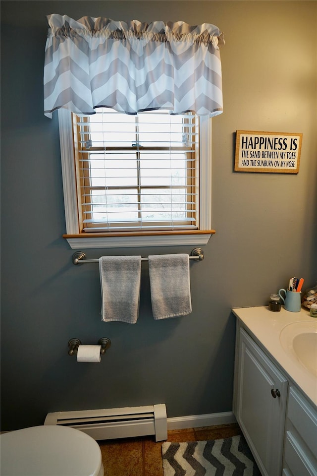 bathroom featuring toilet, tile patterned floors, a baseboard heating unit, and vanity