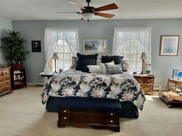 bedroom featuring multiple windows, light carpet, ceiling fan, and a baseboard heating unit