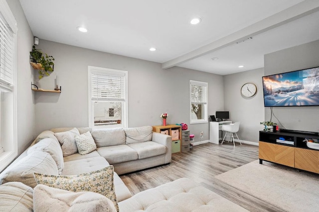 living room featuring beamed ceiling and light wood-type flooring