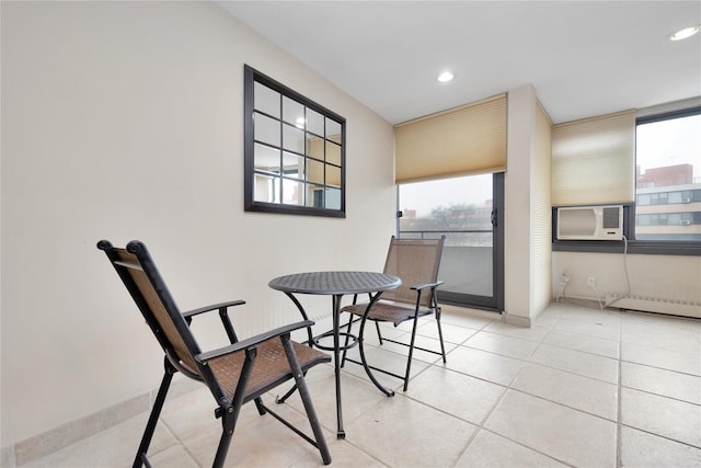 dining area with cooling unit, light tile patterned floors, and a baseboard heating unit