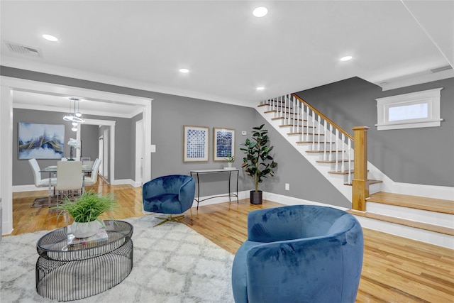 living room with wood-type flooring and ornamental molding