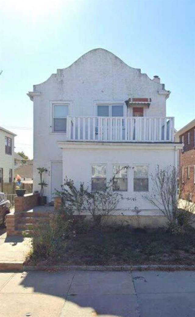 view of front facade featuring a balcony and stucco siding