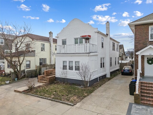 view of front of home with a balcony and concrete driveway