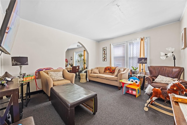 living area with arched walkways and dark carpet