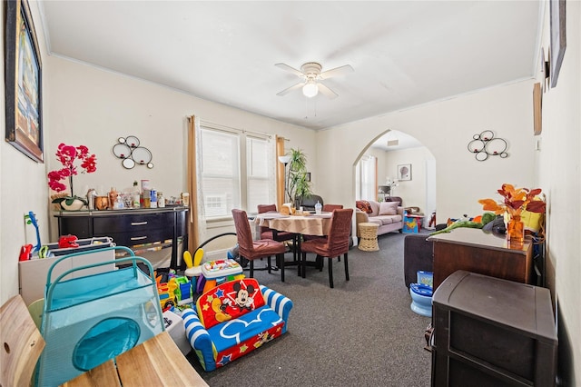 dining area with arched walkways, carpet floors, and ceiling fan