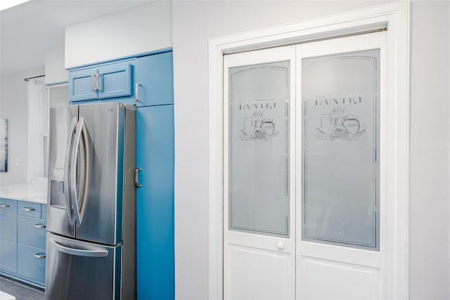 kitchen featuring blue cabinets and stainless steel refrigerator with ice dispenser