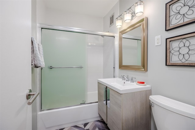 full bathroom with bath / shower combo with glass door, vanity, and toilet