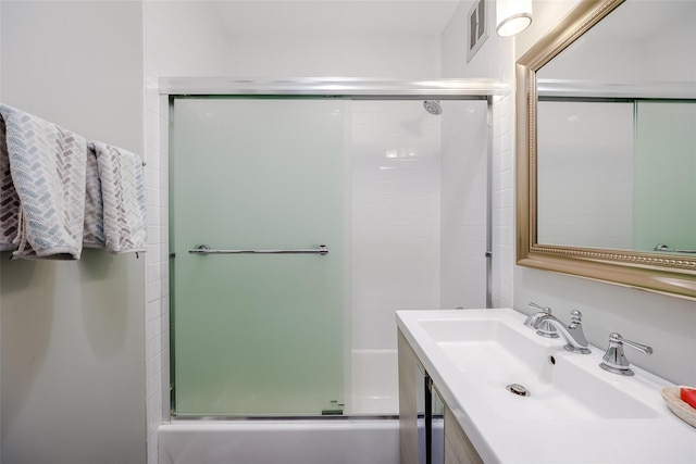 bathroom featuring sink and combined bath / shower with glass door