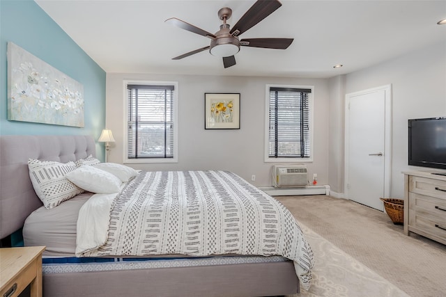 bedroom featuring multiple windows, an AC wall unit, carpet floors, and a baseboard heating unit