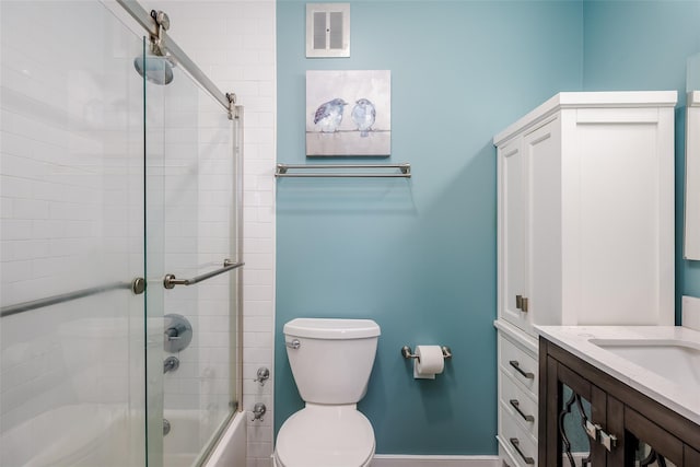 full bathroom with bath / shower combo with glass door, vanity, and toilet