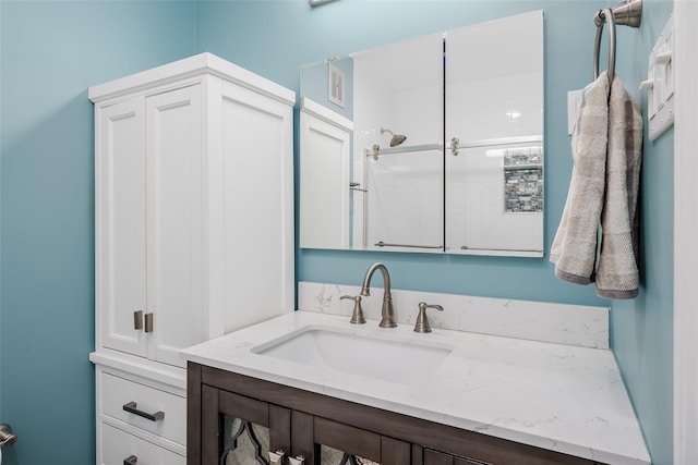 bathroom with vanity and a shower with shower door