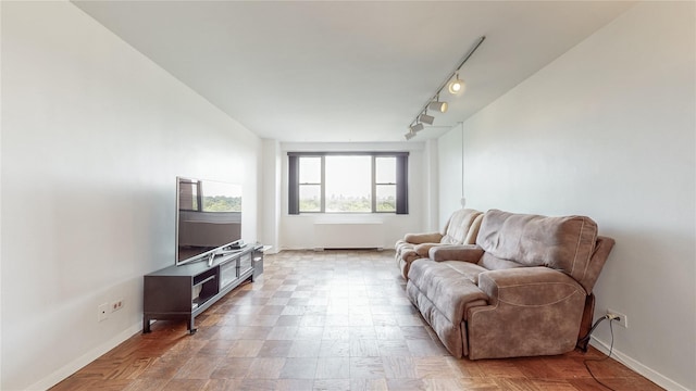 living area featuring rail lighting and baseboards