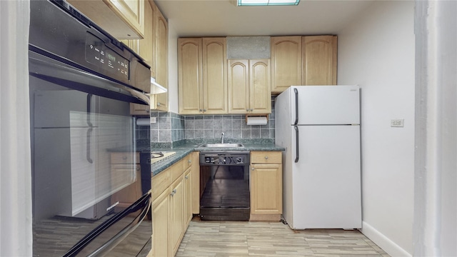 kitchen featuring a sink, light brown cabinetry, black appliances, tasteful backsplash, and dark countertops