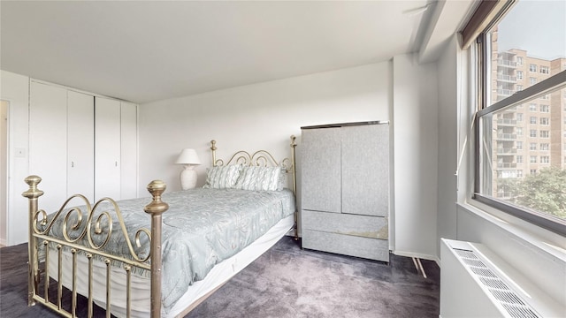 bedroom with dark colored carpet and radiator