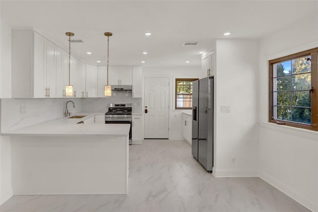 kitchen with appliances with stainless steel finishes, white cabinetry, decorative light fixtures, kitchen peninsula, and tasteful backsplash