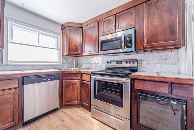 6 Mcgill Rd, Monroe, NY 10950 - kitchen featuring appliances with stainless steel finishes, sink, backsplash, and light wood-type flooring