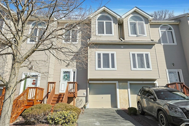 multi unit property with driveway, an attached garage, and stucco siding