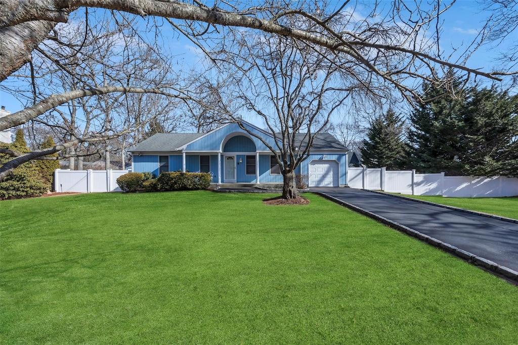 ranch-style home featuring a garage and a front lawn