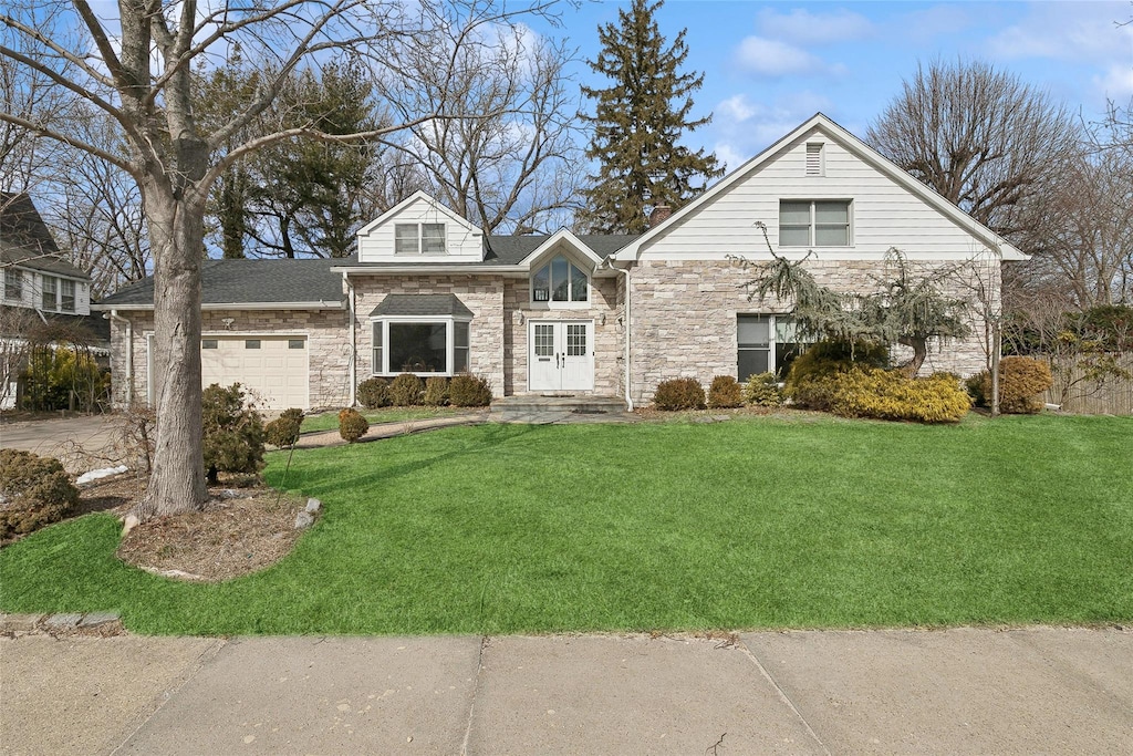 45 Nassau Dr, Great Neck, NY 11021 - view of front of property featuring an attached garage, stone siding, and a front lawn