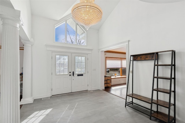 entryway with high vaulted ceiling, baseboards, french doors, ornate columns, and an inviting chandelier