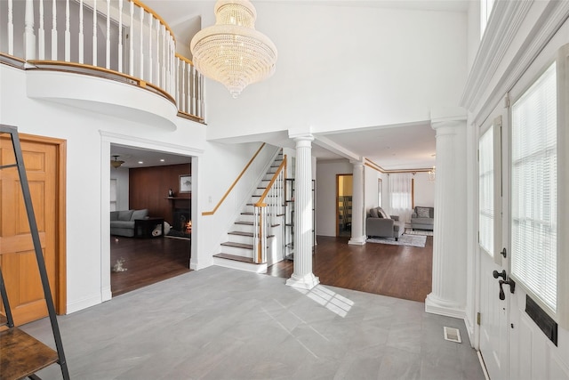 entrance foyer featuring a chandelier, visible vents, and decorative columns