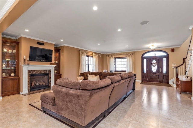 living room featuring ornamental molding, stairway, a fireplace, and recessed lighting