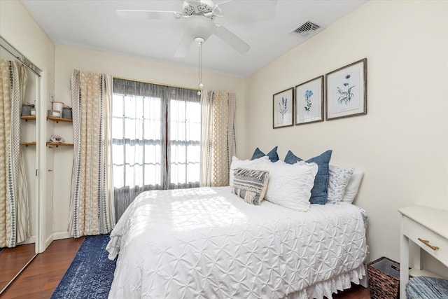 bedroom featuring dark wood-style floors, visible vents, and ceiling fan