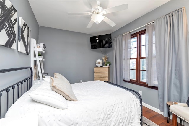 bedroom with ceiling fan, baseboards, and wood finished floors