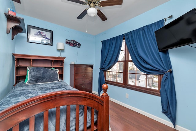 bedroom with wood finished floors, a ceiling fan, and baseboards