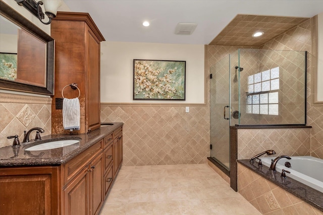 full bathroom featuring recessed lighting, vanity, tile walls, a shower stall, and a bath