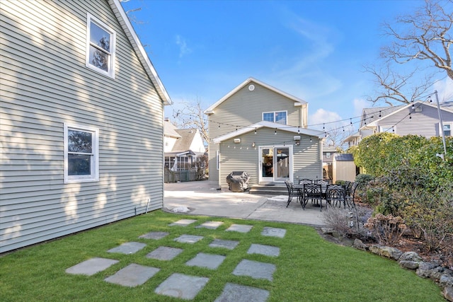 rear view of property with a yard, entry steps, a patio, and fence