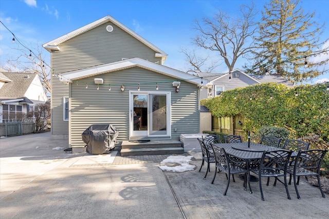 back of house featuring entry steps, a patio area, fence, and outdoor dining area