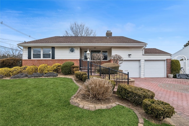 ranch-style house with decorative driveway, brick siding, a chimney, an attached garage, and a front lawn