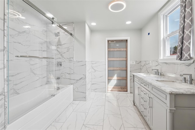 full bathroom featuring marble finish floor, a sink, tile walls, and recessed lighting