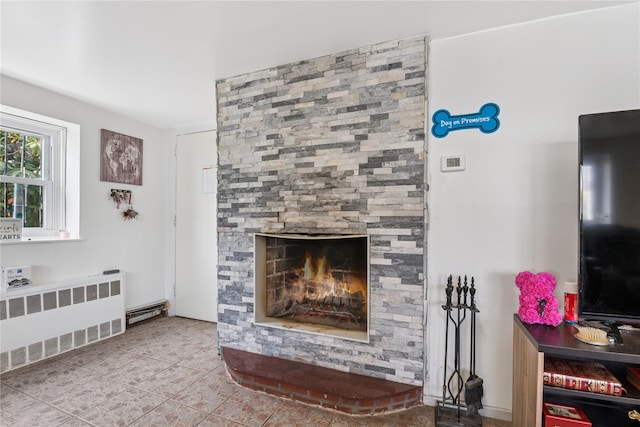 living area featuring a large fireplace, radiator heating unit, and tile patterned floors