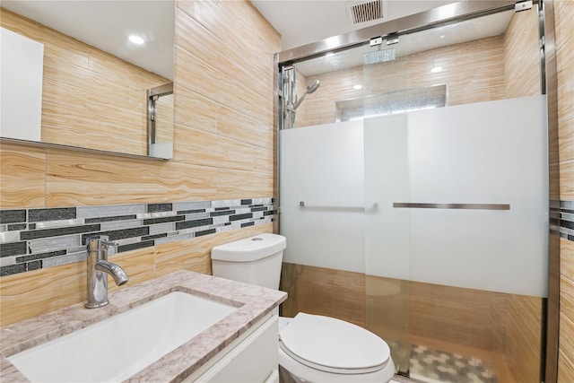 bathroom with toilet, visible vents, a walk in shower, and vanity