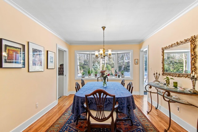 dining room featuring light hardwood / wood-style flooring, plenty of natural light, crown molding, and an inviting chandelier