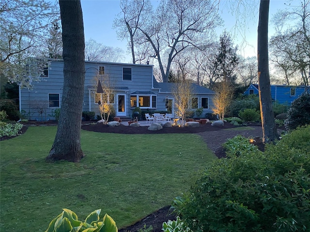 back of property featuring a lawn and a patio area