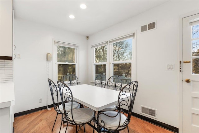 dining room featuring baseboards, visible vents, and light wood-type flooring