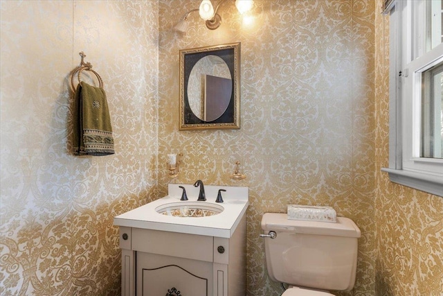 bathroom with wallpapered walls, vanity, and toilet