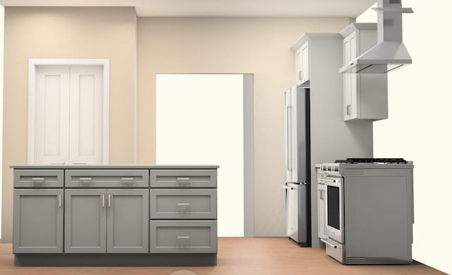 89 Leslie Rd, Newburgh, NY 12550 - kitchen with wall chimney range hood, gas stove, gray cabinets, freestanding refrigerator, and light wood-style flooring