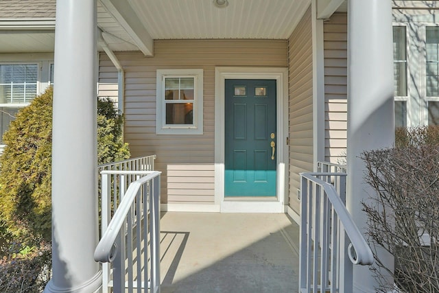 property entrance with covered porch and roof with shingles